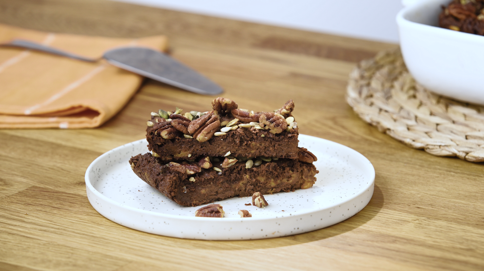 Brownie végan Gerlinéa à la patate douce , au chocolat, graines et noix sur une assiette blanche