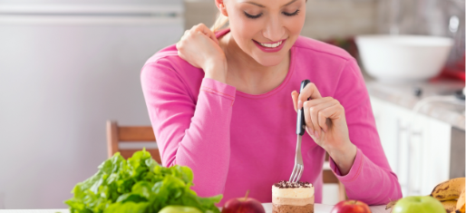 femme qui mange un dessert entouré de fruits et légumes